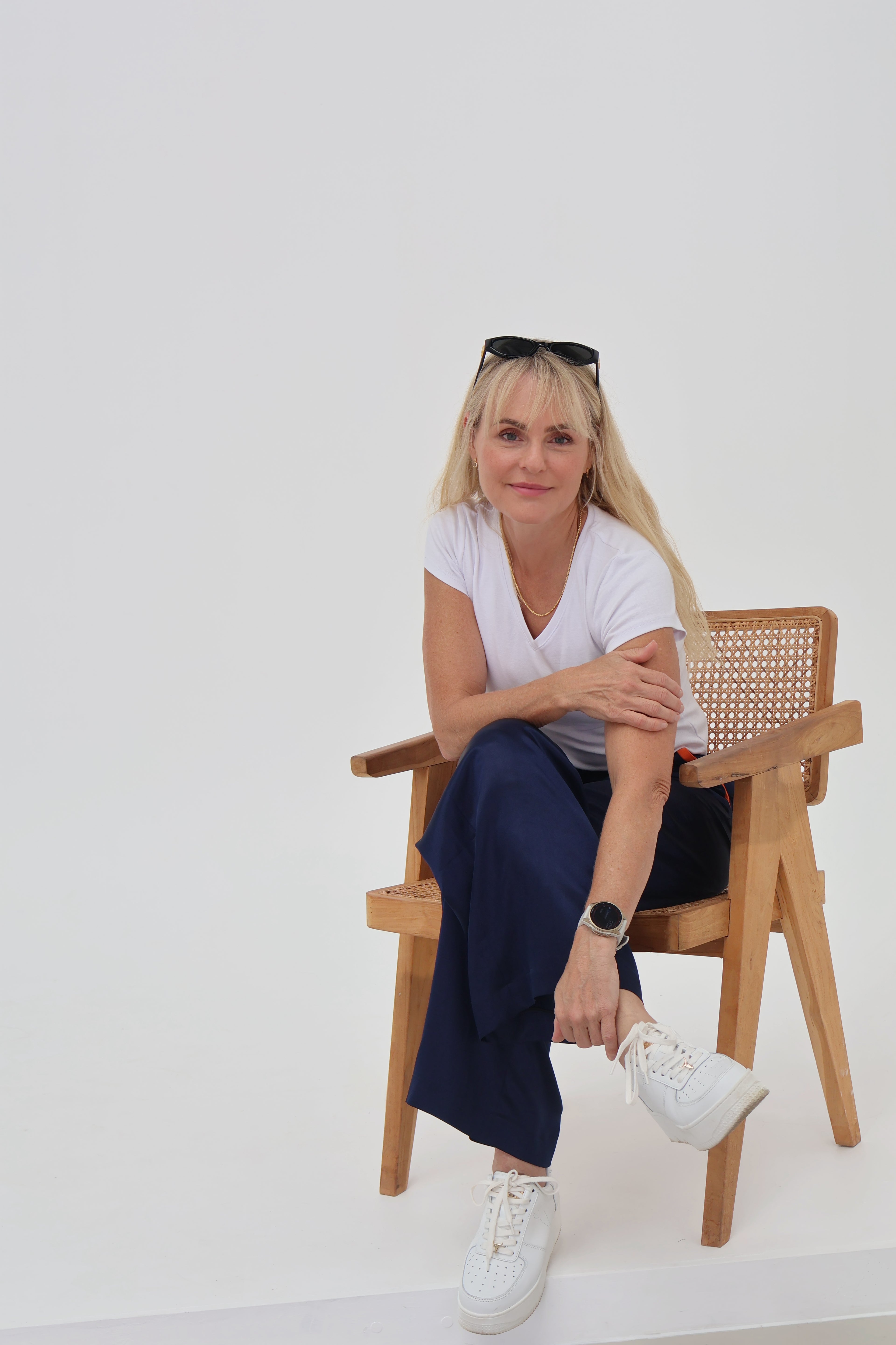 Mae, founder of Mae Bespoke, seated wearing handcrafted gold-filled jewellery